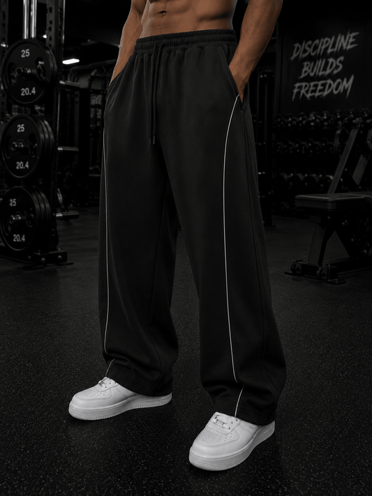 Elevate Single Stripe Sweatpants in black, perfect for casual and sporty looks, styled with white sneakers.