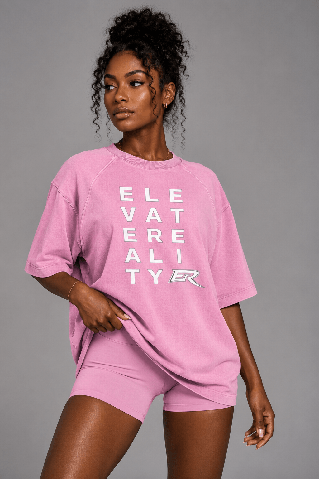 Woman wearing matching pink Short Sleeve Pump Cover and athletic shorts set front view