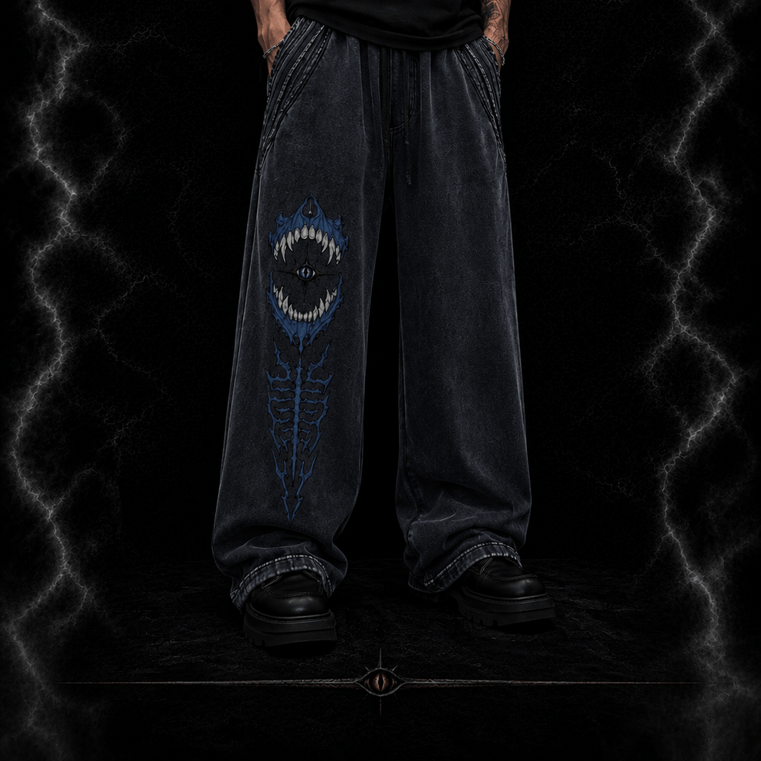 Person wearing dark jeans with a unique design on a dark background