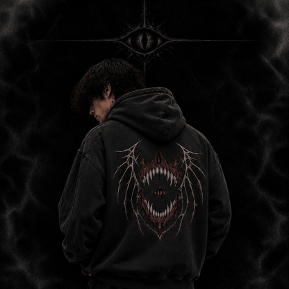 Person wearing a black hoodie with a design on the back against a dark background, featuring 'The Witness Collection' branding.